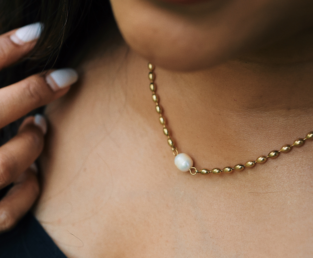 a woman wearing a pearl pendant necklace